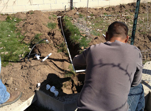 our Pasadena sprinkler installation tech is placing the new pipes in the ground